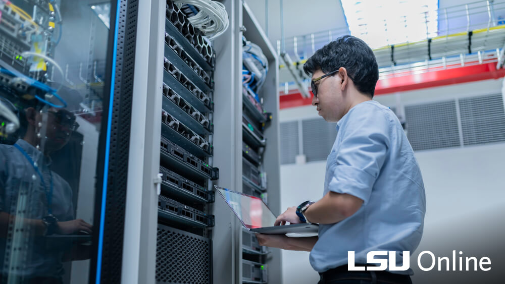 Energy employee working in a server room with network equipment racks.